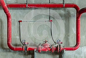 Red water or gas pipeline with gate pressure valve on concrete wall. Industrial tubes and valves, Line pipe industrial and