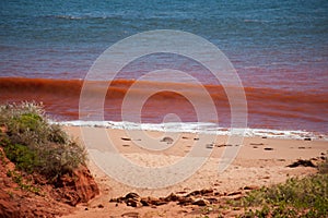 Red waves breaking on beach at high tide at James Price Point, Kimberley, Western Australia