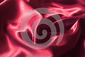 Red wavy silk textile texture background selective focus