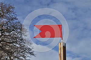 Red weather vane against blue sky