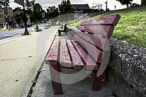 Red weathered park bench