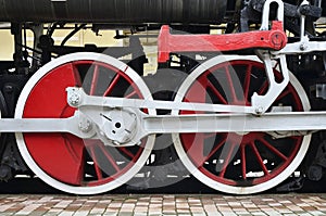 Red wheels of old USSR black steam locomotive. Wheels of an old soviet steam trai