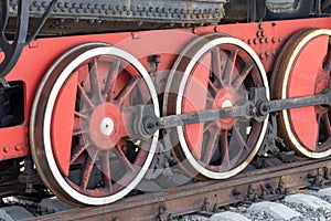 Red wheels of a vintage steam train locomotive close up, detail of a train of great world war times