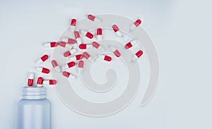 Red-white antibiotic capsule pills spread out of white plastic drug bottle. Antibiotic drug resistance concept. Antibiotic drug photo