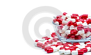 Red, white antibiotic capsules pills in glass bowl