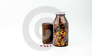 Red, white antibiotic capsules pills and two amber bottles isolated on white background with copy space and blank label.