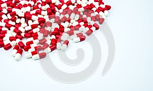 Red, white antibiotic capsules pills on white background with copy space.
