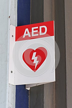 Red and white Automated External Defibrillator AED sign in a public place