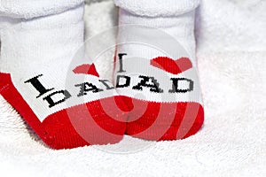 Red and white Baby socks on white blanket showing love to mother text