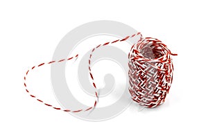 Red and white bakers twine rope spool isolated on white background.