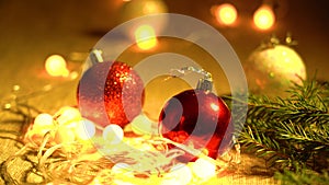 Red, White Balls, Coniferous Branches and Garlands of Yellow Lamps Lie on a Table Close-up. Christmas Holidays and