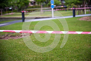 Red and white Barricade tape defining border of restricted area of construction work in progress