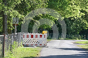 Red white barricade with warning lights as a safety measure for earthworks during cable and fiber optics laying on a country road