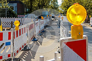 Red and white barricades with warning lights on a street in a re