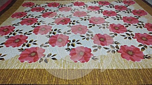 Red and white bedsheet with floral print on it