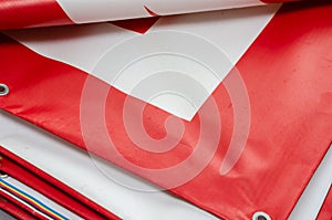 A red and white billboard. PVC fabric folded. Banner with eyelets