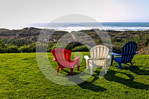 Red, white and blue adirondack chairs overlooking the Pacific Ocean in Bandon Beach, Oregon