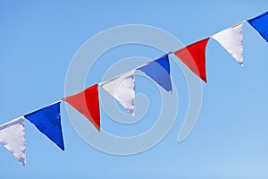 Red, white and blue flags on a blue sky background