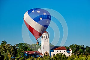 Red white and blue hot air balloon in front of the iconic Boise Train depot