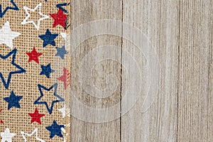 Red, white and blue stars burlap ribbon on weathered wood background