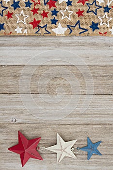 Red, white and blue stars burlap ribbon on weathered wood background