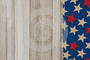 Red, white and blue stars burlap ribbon on weathered wood background