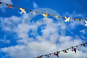 Red white and blue triangular bunting on sky background. Garland of flags stretched against a blue sky with white clouds