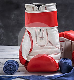 Red-white boxing gloves and a blue textile bandage