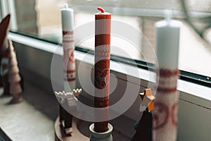 Red and white candles near the window for a Christmas decoration