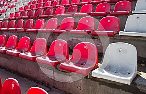Red and white chairs at the old empty stadium.