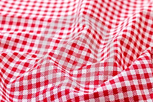 Red and white checkered fabric texture. Crumpled bright colored cotton background. Selective focus. Closeup view