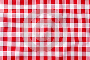 Red and white checkered tablecloth. Top view table cloth texture background. Red gingham pattern fabric. Picnic blanket texture.