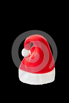 Red and white christmas hat in black background. Santa claus cap on the plain dark background