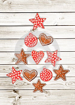 Red and white Christmas tree made of wooden rustic ornaments on white wooden planks background greeting card