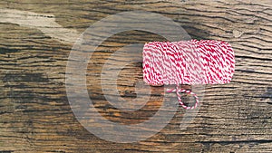 Red&white Coil rope with roll end on old wooden