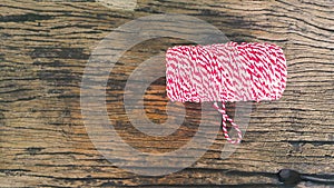 Red&white Coil rope with roll end on old wooden table