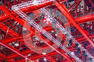 Red and white colored metal construction wih snowflake under roof of ice arena
