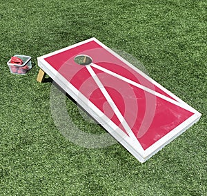 Red and white cornhole game on a green field