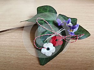 Red and white crocheted flowers martisor with violet spring flowers