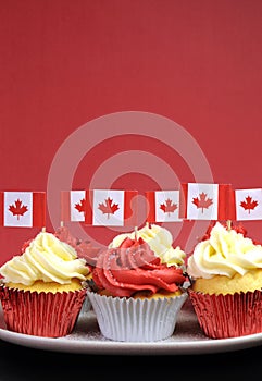 Red and White cupcakes with Canadian maple leaf national flags - vertical with copyspace.