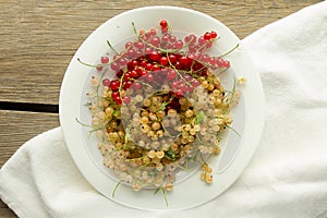 Red and white currant on white plate