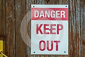 A red and white danger keep out sign attached to a door