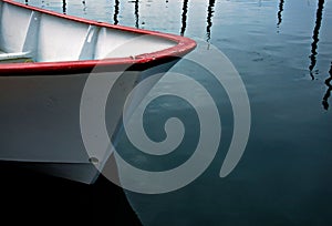 Red and white dory floating on calm waters. photo