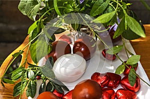 Red and white Easter eggs and chocolate hearts,bouquet of periwinkleÃÂ with ladybug on leaf