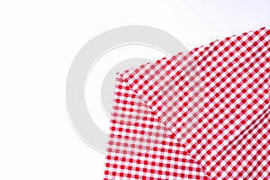 Red and white fabric tablecloth checkered on white background with copy space.
