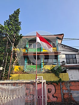 red and white flag fluttering in front of the house