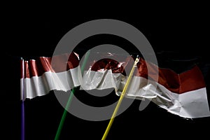 Red and white flag made of plastic on a black background. Suitable for Indonesia`s big days such as Indonesian Independence Day,