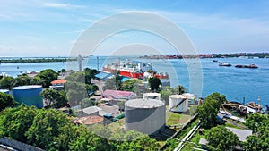 Red and white Floating Storage and Regasification Unit, FSRU, LNG-vessel in Benoa Harbour under light blue sky.