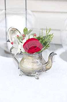 Red and White floral arrangement in antique teapot