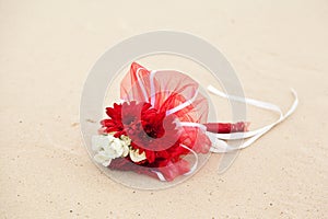 Red and white flowers wedding bouquet on sand